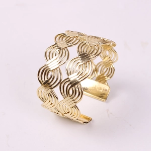 Macro view of golden woven wire napkin ring with a decorative metal lantern shape design