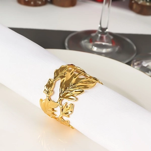 Golden maple leaf napkin ring with hollow design on white cloth for table decoration