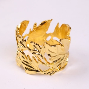 Detailed close-up of golden leaf napkin ring with intricate vein textures and metal plating