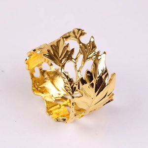 Macro shot of gold leaf napkin ring with intricate hollowed-out maple leaf pattern