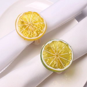 Detail of artificial lemon and lime slice napkin rings on white ceramic dinnerware