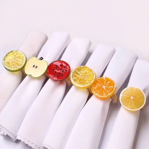Detail showing various fruit napkin rings with citrus slices and natural wooden loops
