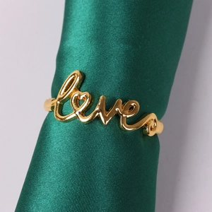 Gold LOVE napkin ring with heart design on green satin holder for Valentine table