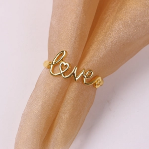Macro shot of gold-plated Love napkin ring with a heart-shaped O on silk fabric