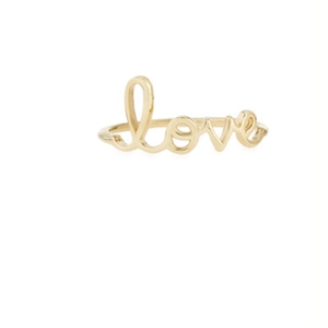 Close-up of elegant gold napkin ring featuring a minimalist cursive love script design