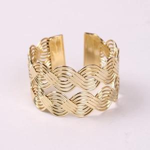 Elegant gold metal woven napkin ring with a wave pattern and open lantern-style design
