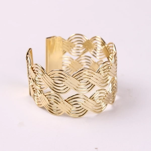 Golden open cuff bracelet with intricate woven hollow pattern and wavy metallic texture