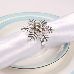 Silver snowflake napkin ring with rhinestones on a white silk napkin for Christmas decor