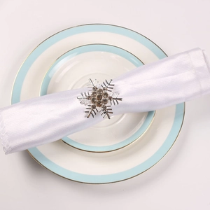 Close-up of silver snowflake napkin ring with rhinestones on a white napkin