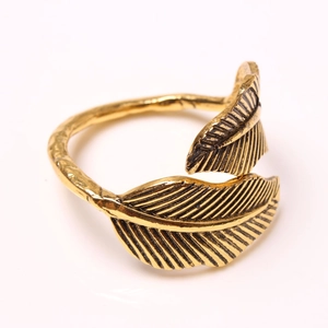 Adjustable golden leaf napkin ring with vintage etched texture on a white background