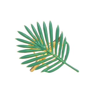 Green palm leaf napkin ring with gold base for elegant dining table decor