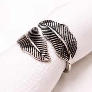 Macro shot of antique silver feather napkin ring featuring intricate leaf vein textures