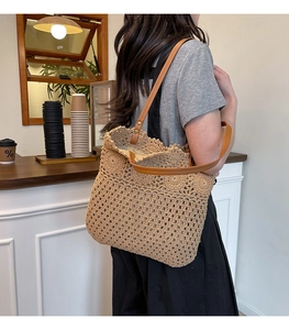 Close-up of hand-woven hollow crochet tote bag with durable brown synthetic leather straps