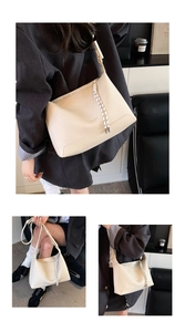 Detail of off-white lychee grain leather tote with a unique woven zipper drawstring cord