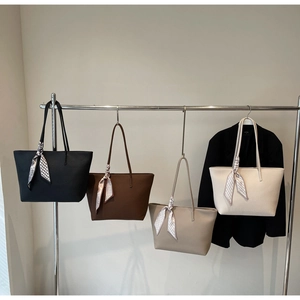 Detail of four large lychee pattern leather tote bags in various colors with silk scarves