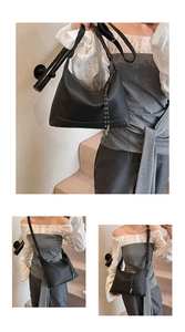 Detail of black lychee texture tote bag with adjustable strap and decorative knot charm