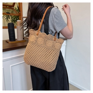 Detail of hollow woven tote bag with cotton rope craft and brown leather shoulder straps