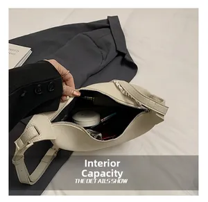 Detail view of beige crescent bag interior capacity showing storage for makeup items