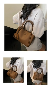 Detail der braunen Leder-Eimertasche mit Litschi-Maserung und süßem Elefanten-Anhänger