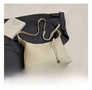 Detail view of the off-white lychee grain leather hobo bag with braided strap accents