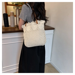 Detailed look at the hollow crochet tote bag with flower patterns and leather strap