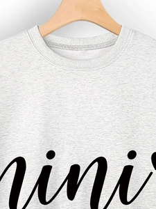 Close-up of ribbed crew neck and black mini script print on gray sweatshirt