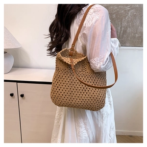 Detail of hollow woven cotton rope bucket bag with synthetic leather shoulder strap