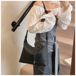Litchi pattern leather shoulder bag shown on model with woven rope accessory