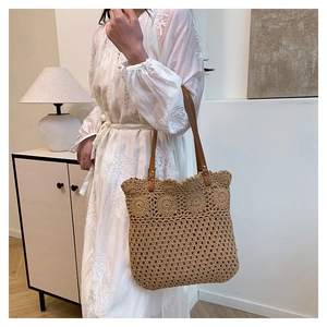 Detail view of khaki woven cotton rope shoulder bag with flower crochet and leather strap