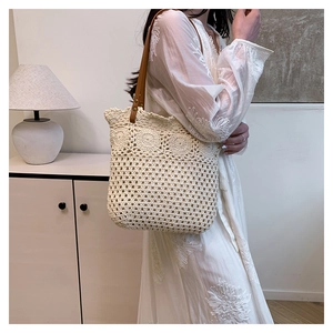 Detail of hollow-out mesh crochet tote bag with sun flower patterns and leather straps
