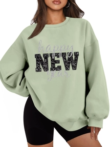 Details des minzgrünen warmen Sweatshirts mit glitzerndem happy NEW year Textaufdruck