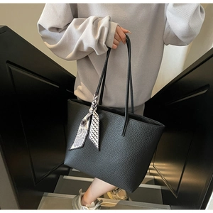 Detailed macro view of black lychee grain tote bag with decorative geometric floral silk scarf