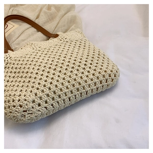 Detailed macro view of cream woven cotton cord texture and brown faux leather handle