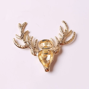 Macro view of golden metal deer head decoration showing detailed antlers and back clasp
