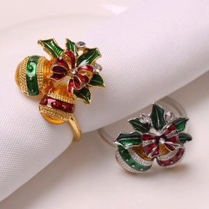 Christmas napkin ring set with bells, red bows and holly leaves on white fabric