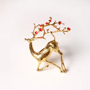 Détail d'un rond de serviette cerf doré avec d'élégants accents floraux rouges