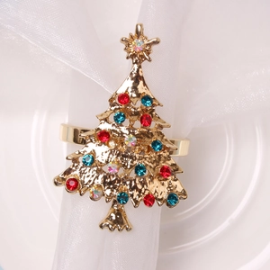 Golden Christmas tree napkin ring with colorful rhinestones on white napkin and plate