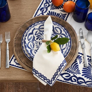 Artificial lemon napkin ring with greenery on white embroidered cloth for table decor