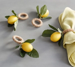 Close-up of lemon napkin rings featuring yellow fruit, green leaves and rustic hemp rope