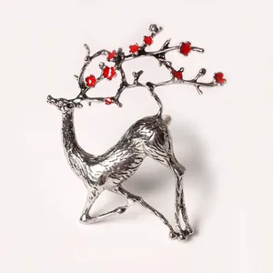 Rond de serviette cerf argenté avec fleurs rouges pour décoration de table élégante