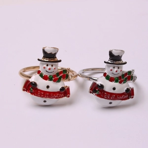 Detailed view of snowman napkin rings with LET IT SNOW inscription on colorful scarves