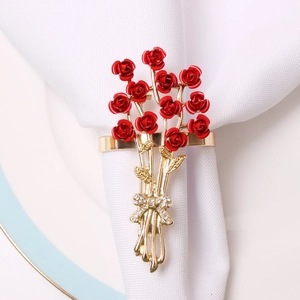 Elegant red rose napkin ring with golden alloy leaves and crystal bow on white napkin