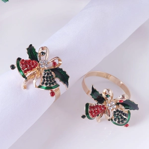 Detail of Christmas bell napkin rings with red and green rhinestones on white linens