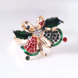 Detail of Christmas napkin ring featuring gold bells and holly leaves with red rhinestones