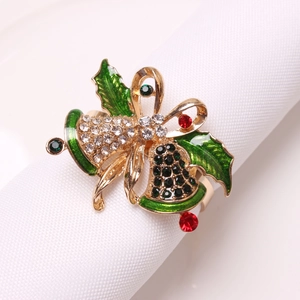 Detailed close-up of a festive golden Christmas napkin ring with bell and holly leaf