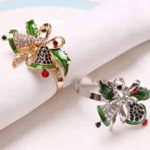 Detail of Christmas napkin rings with enamel holly leaves and sparkling bell rhinestones