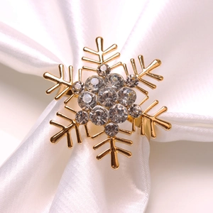 Classic golden snowflake napkin ring with sparkling crystals on white satin background