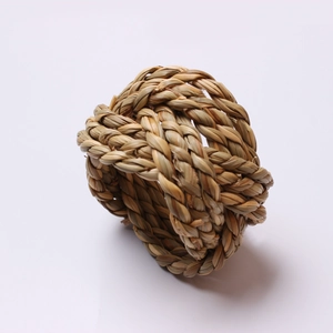 Handmade woven corn husk napkin ring set with natural braided texture on white background