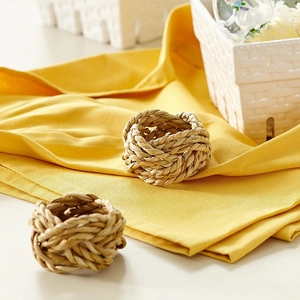 Close-up of handmade woven corn husk napkin rings with a natural rustic straw texture