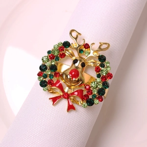 Close-up of golden reindeer napkin ring with festive red and green crystal rhinestones
